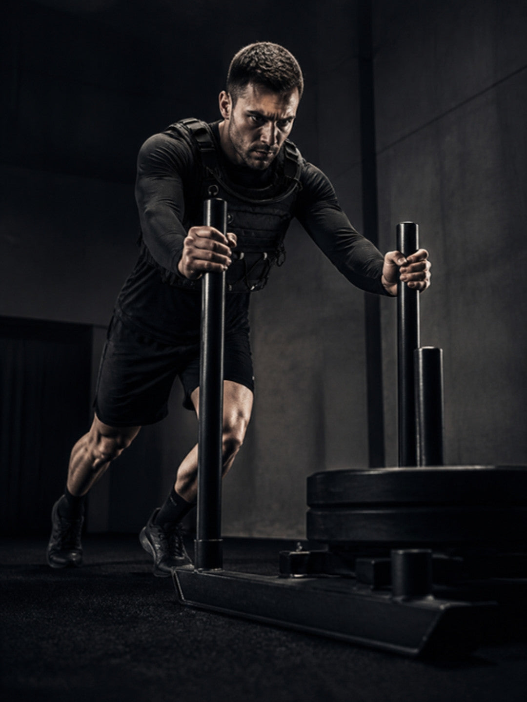 Athlete pushing a sled wearing the Gliho Hybrid Chest Rig